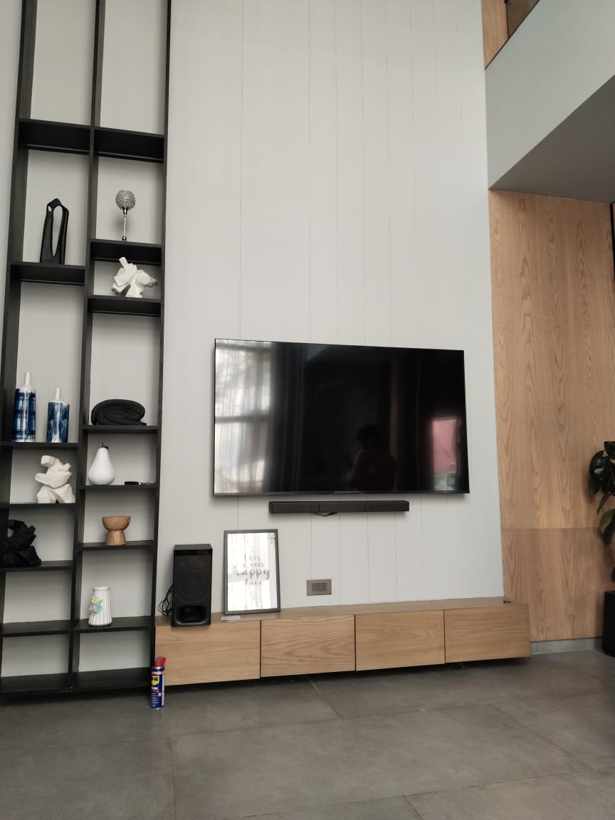 TV wall with shelving and wood panel